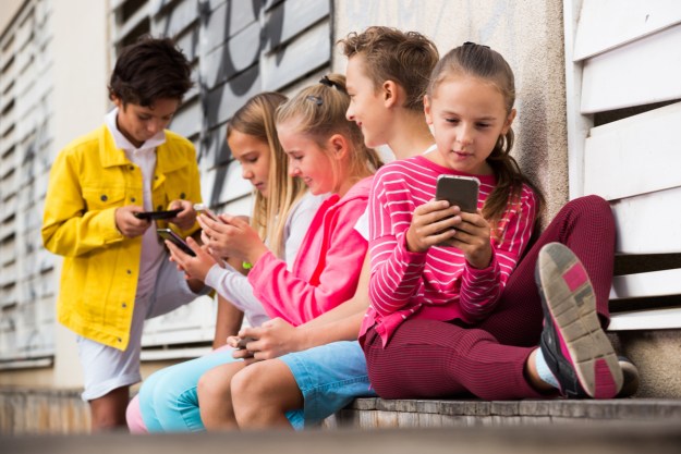 A group of kids on their phones.