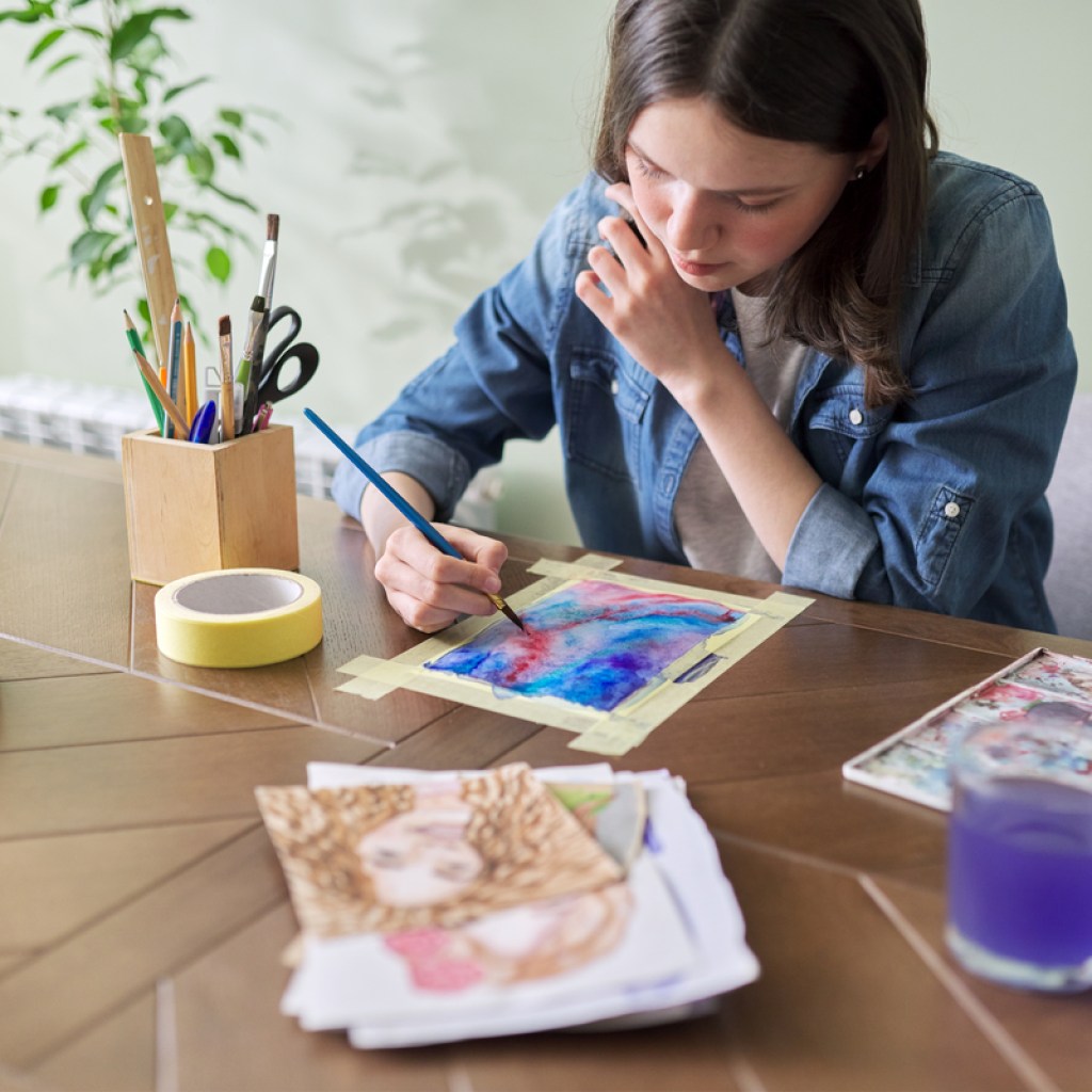 Teen painting at a table