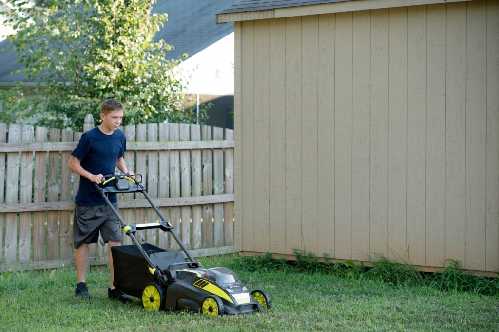 Teenage boy mowing the lawn