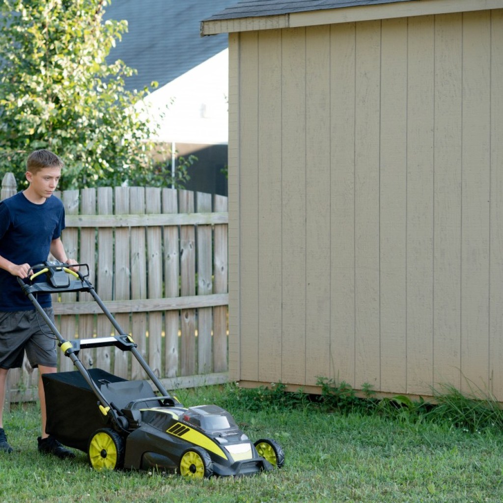 Teenage boy mowing the lawn