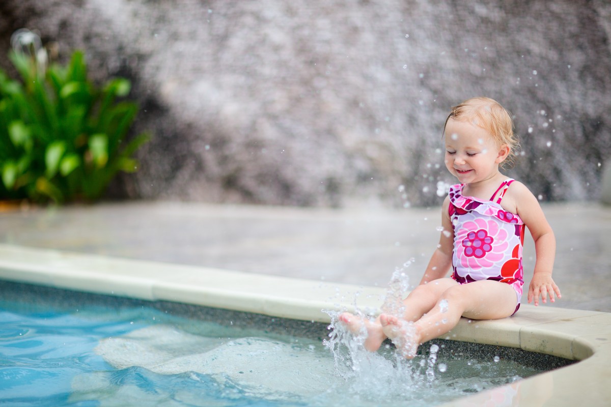 toddler dipping feet in pool