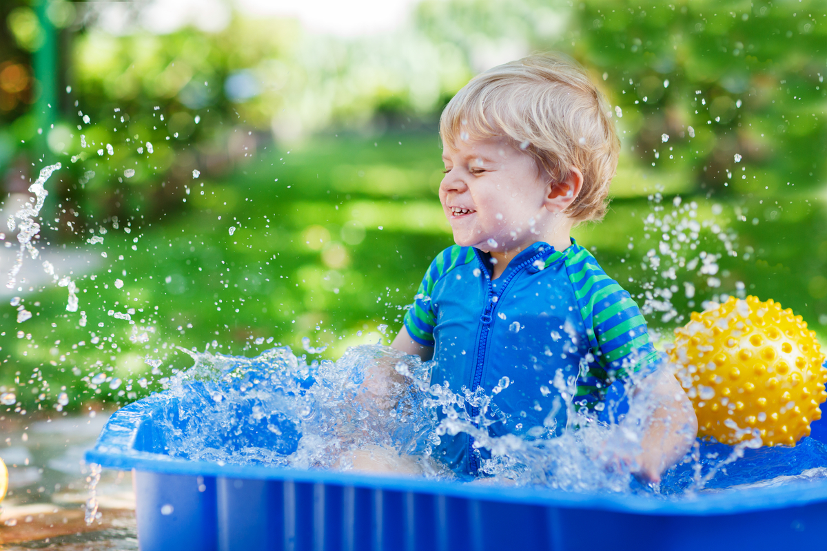 Toddler boy playing in kiddie pool