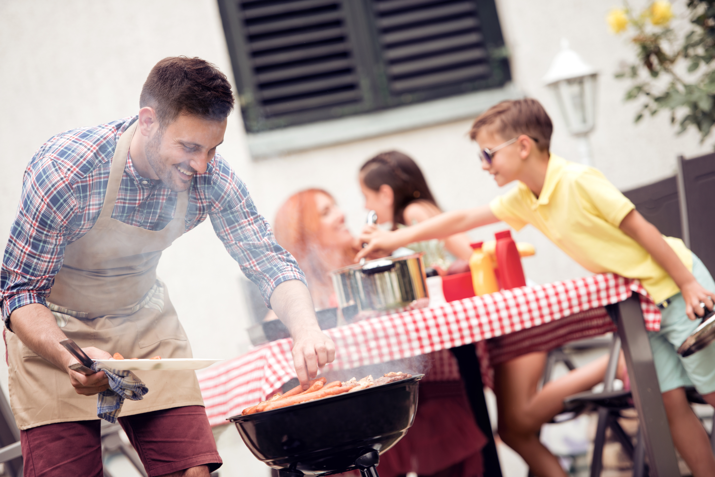 Man cooking with kids in background