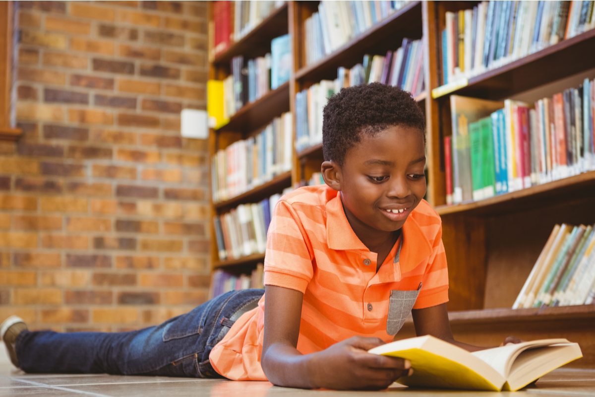 Boy reading book in library