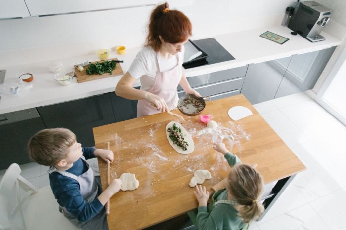 A parent and kids baking together in the kitchen.