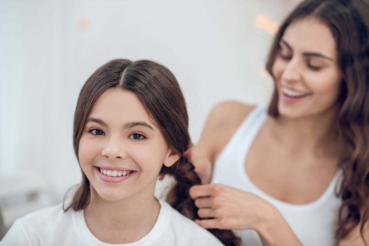 mom fixing daughter's hair