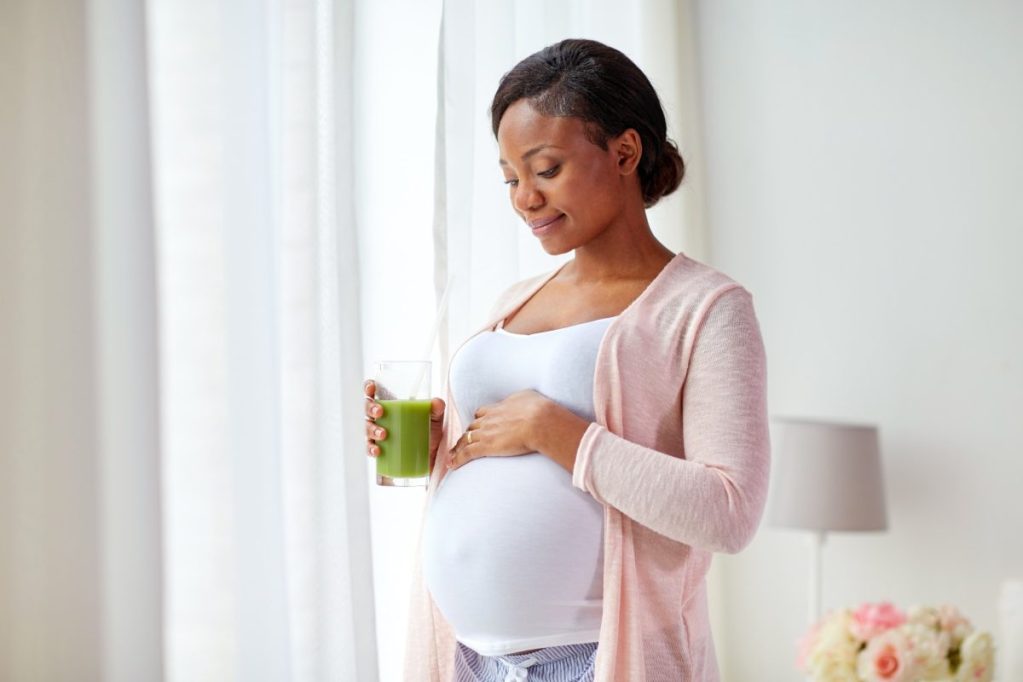 Pregnant woman drinking juice.