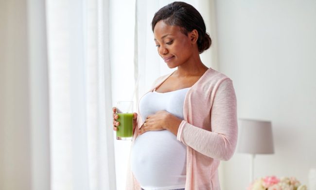 Pregnant woman drinking juice.