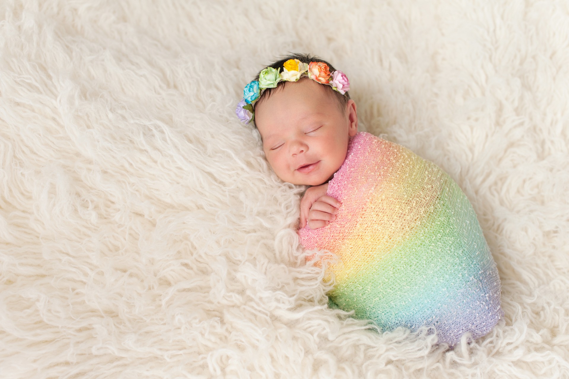 sweet baby girl sleeping in a rainbow blanket