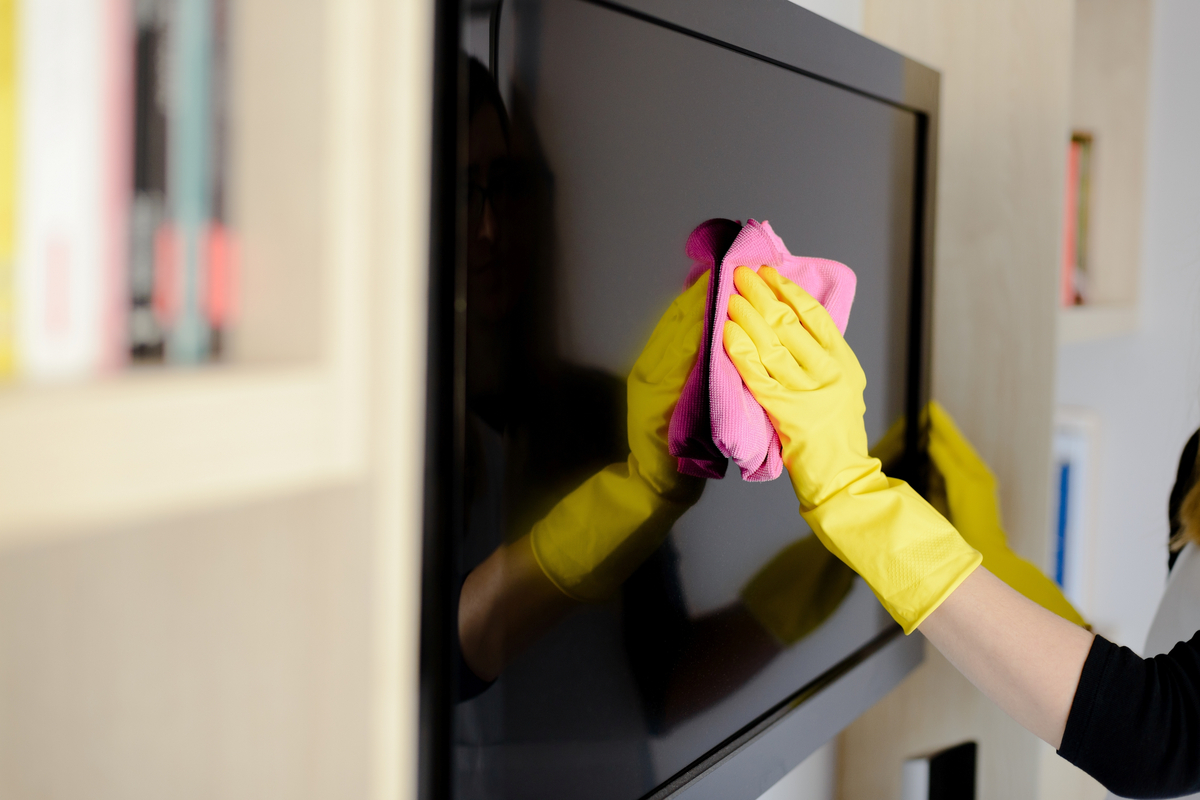 woman giving her television screan a cleaning