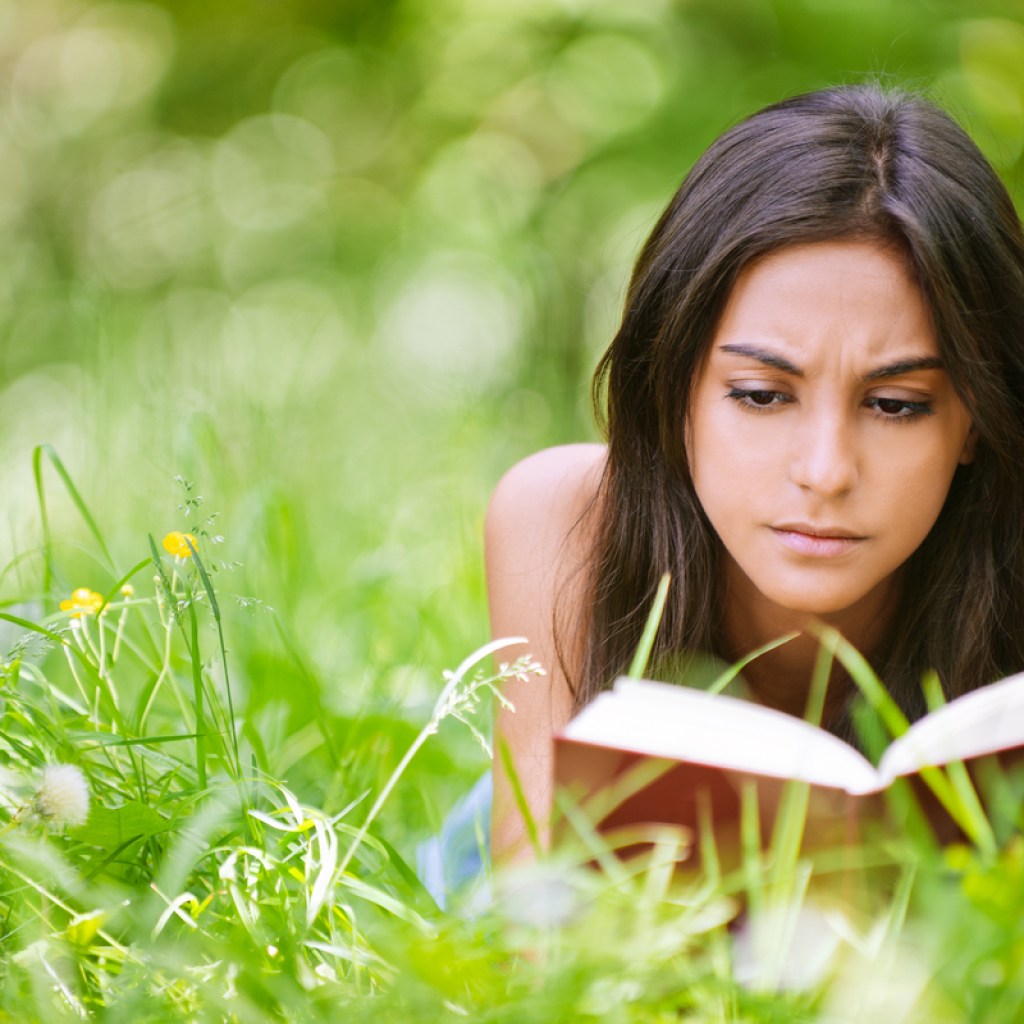 Teen enjoying a summer read in the park