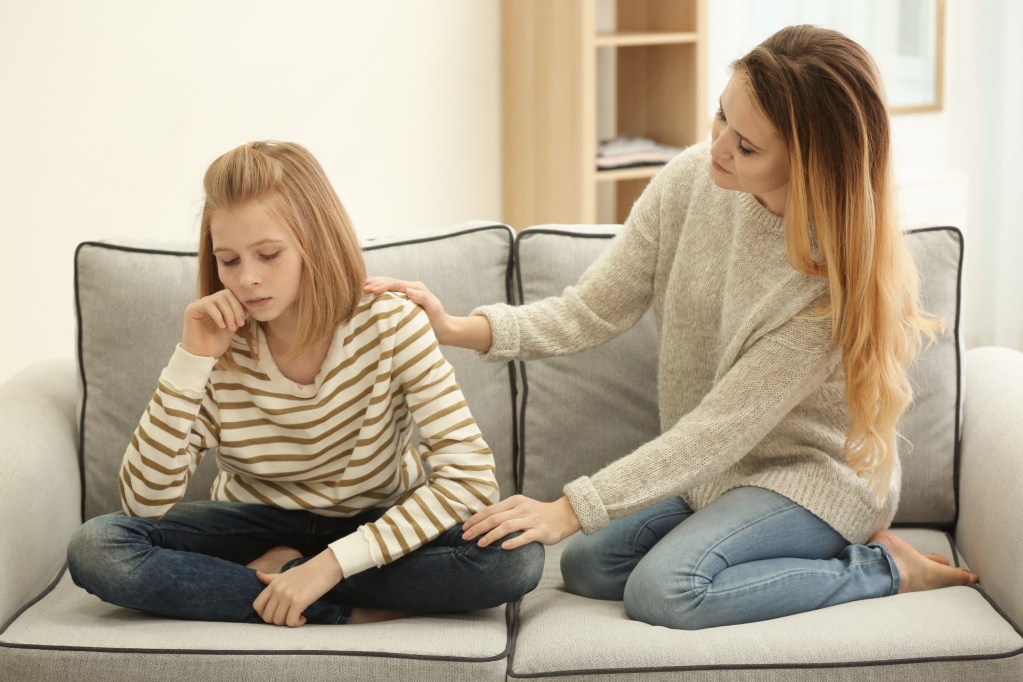 Mom trying to comfort upset teen girl.