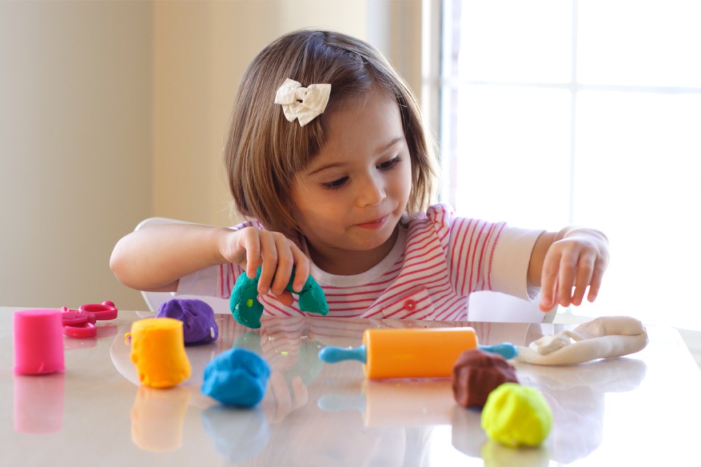 little girl having fun playing with homemade playdough