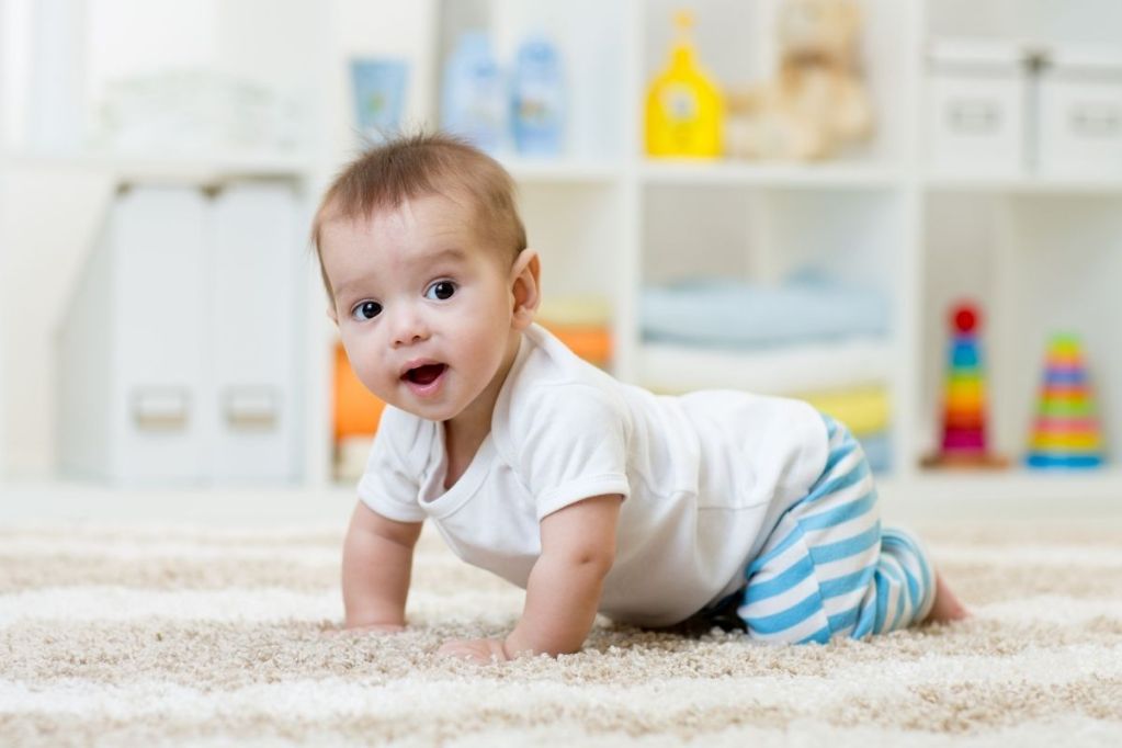 Cute baby crawling across a rug