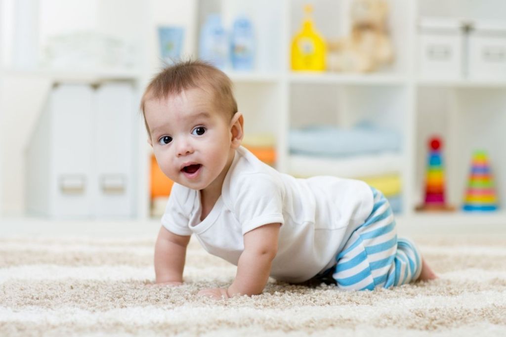 Cute baby crawling across a rug