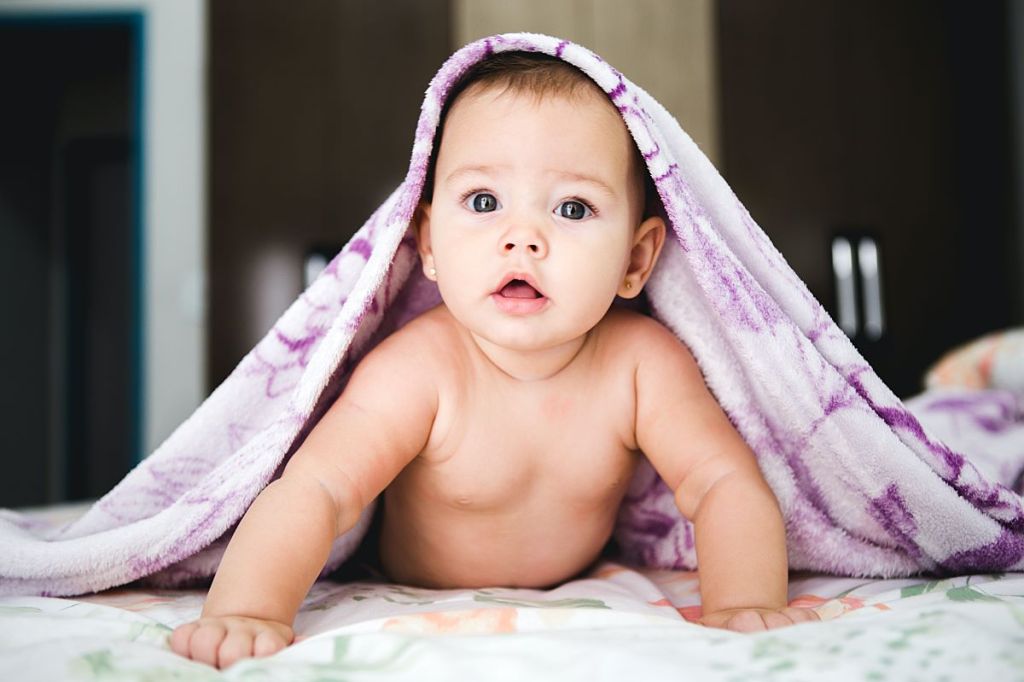 baby girl on tummy under blanket