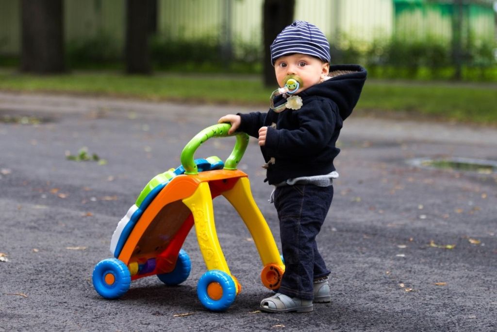 cute baby taking a stroll outside with a walker