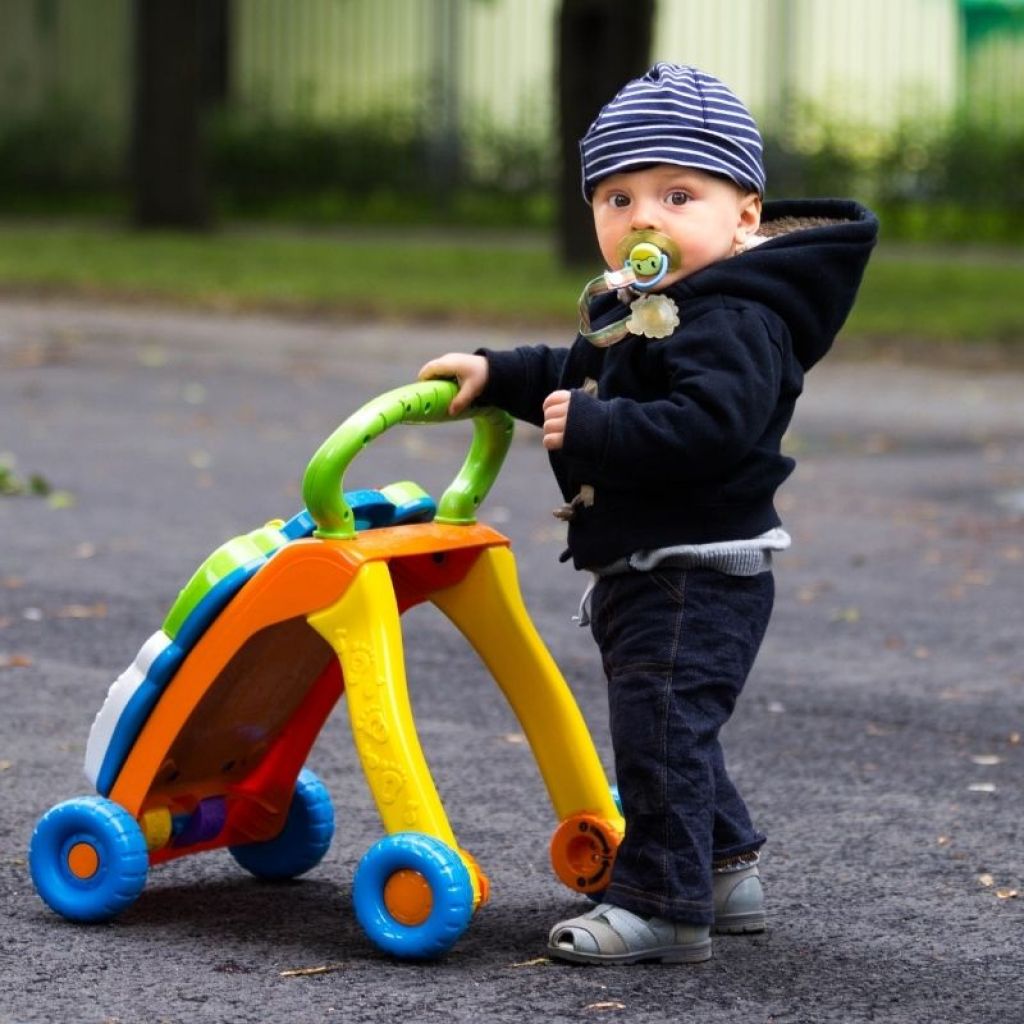 cute baby taking a stroll outside with a walker