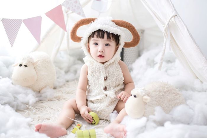 baby with stuffed animals and pink