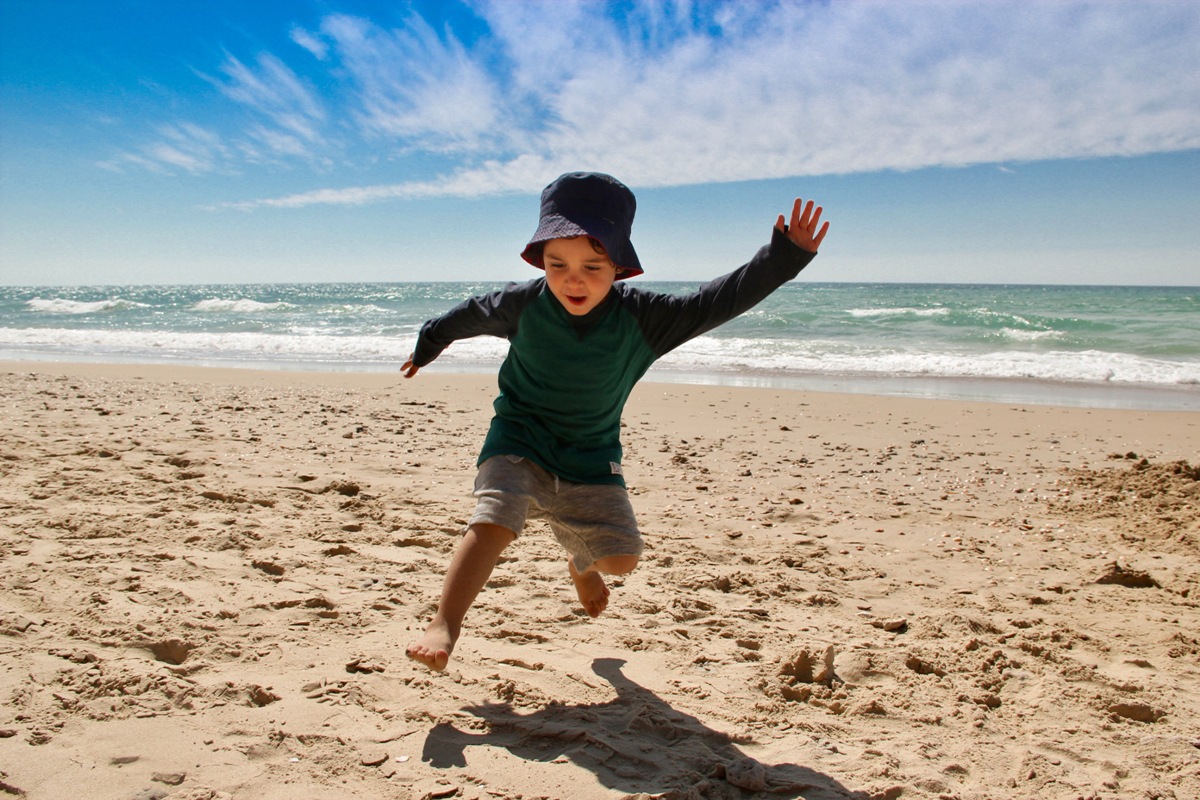 boy doing animal walk on beach