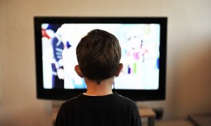 child standing in front of tv