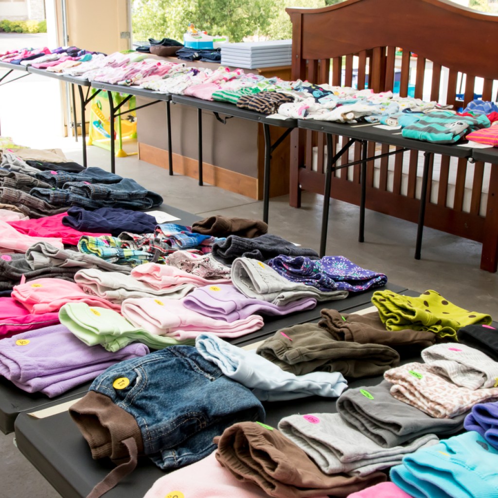clothing for sale neatly set up on tables at garage sale