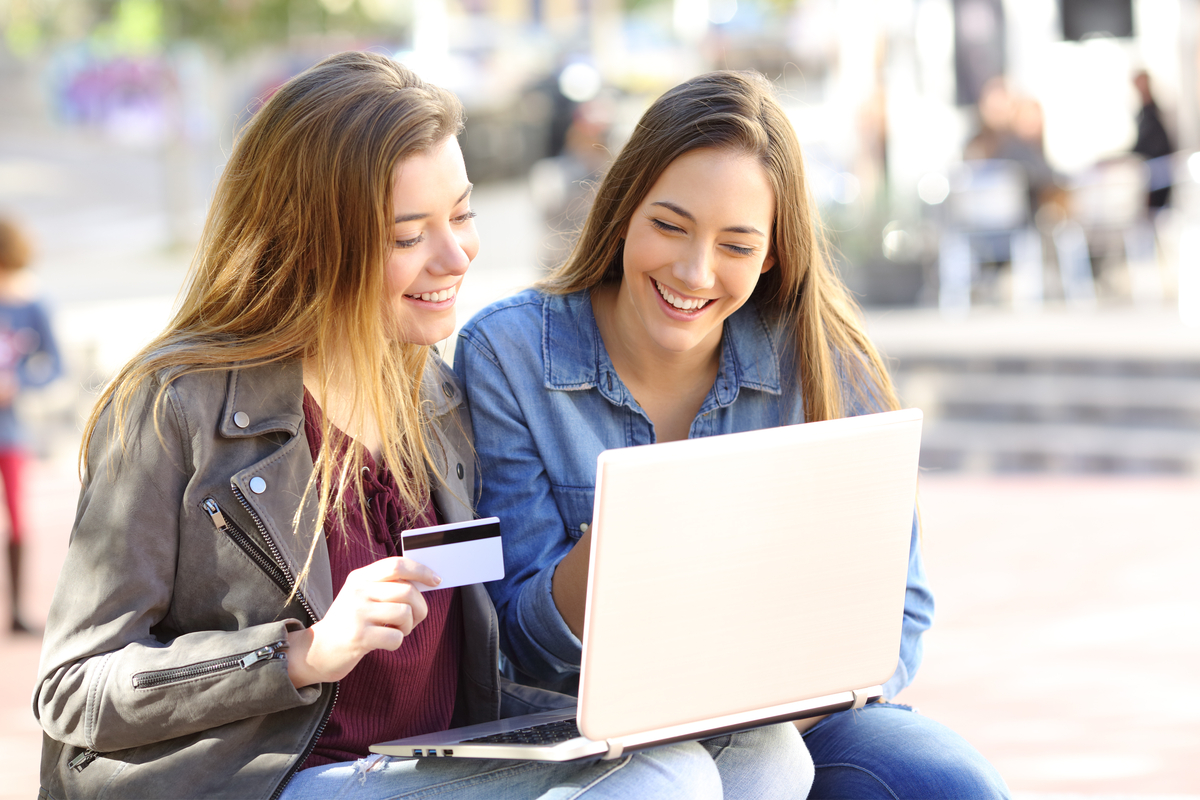 two college teens shopping online with credit card