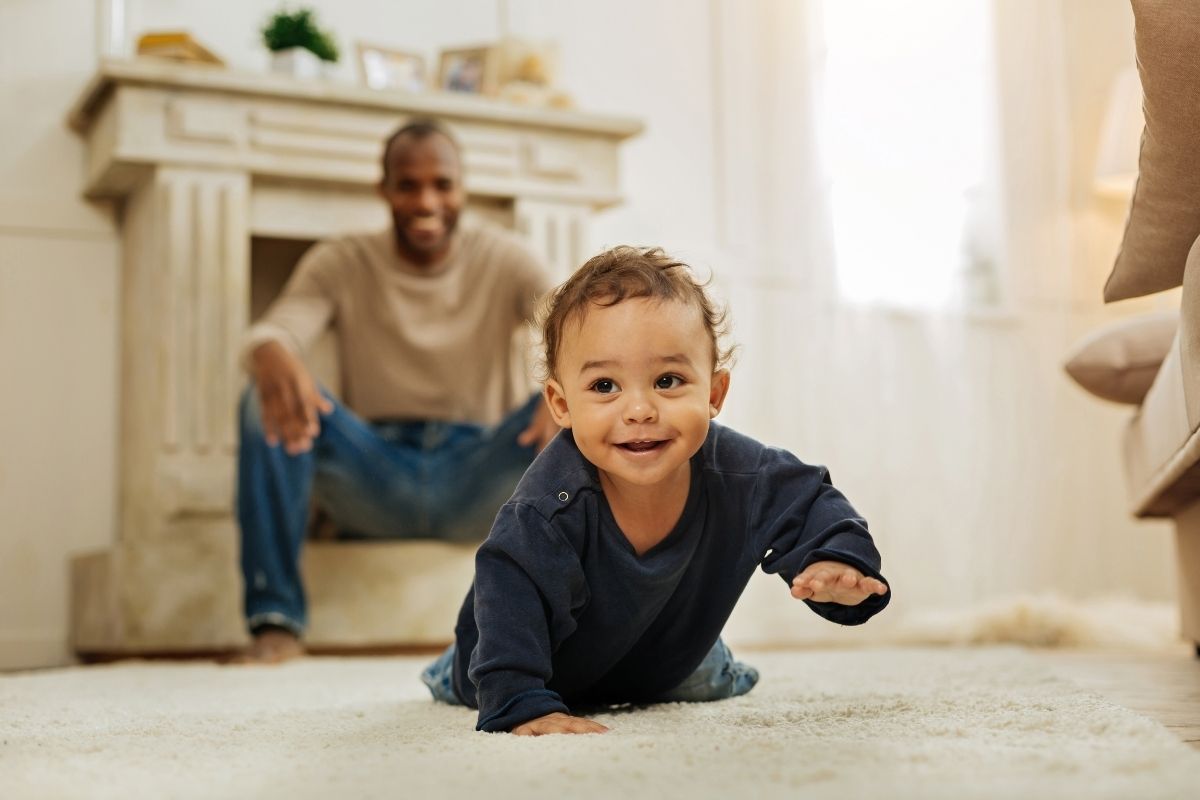 A baby crawling away from their parent.