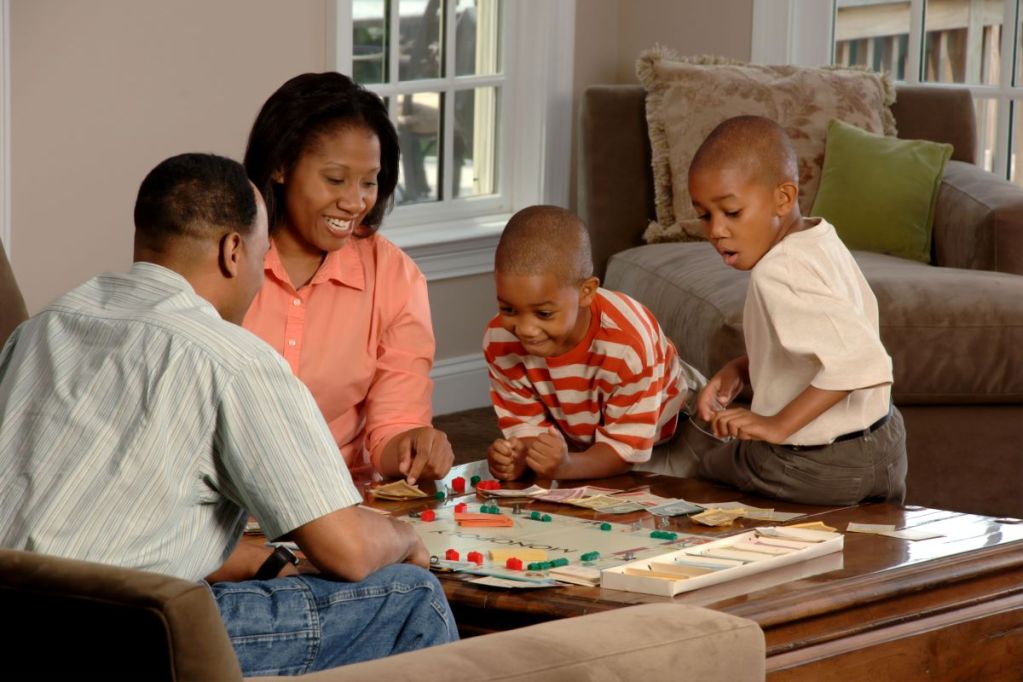 parents with children playing a board game.