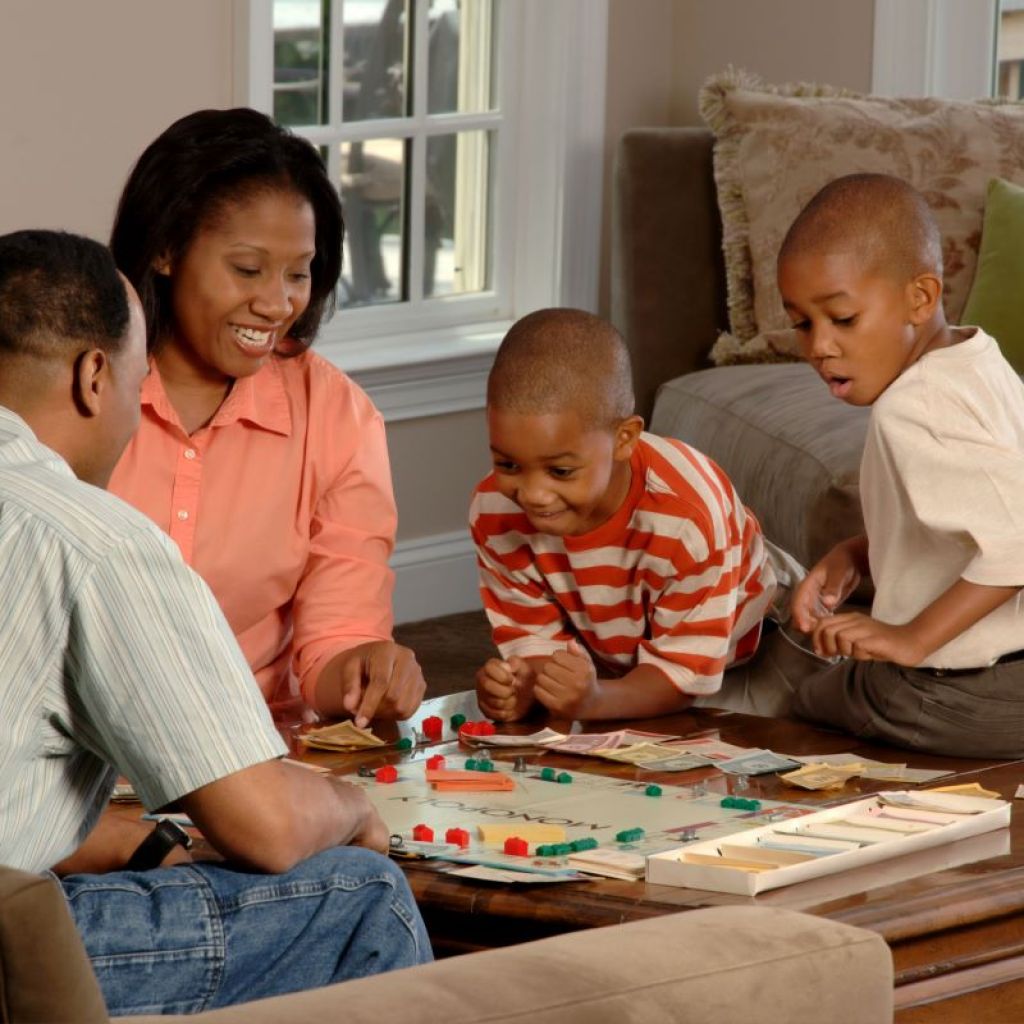 Parents with children playing a board game
