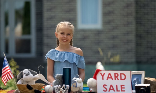 young girl selling her old toys at a garage sale