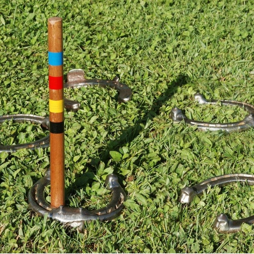 A game of horseshoes set up outside in the grass.