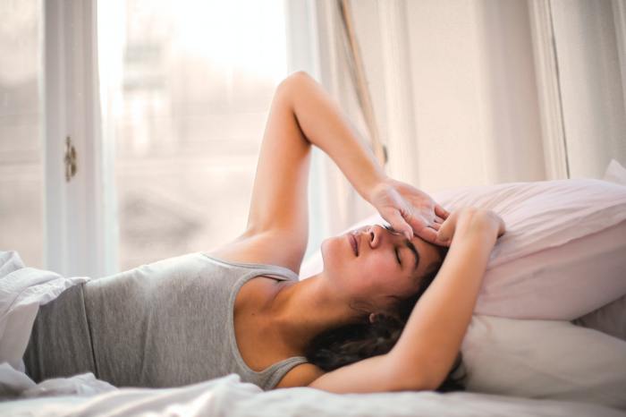 woman laying down with headache