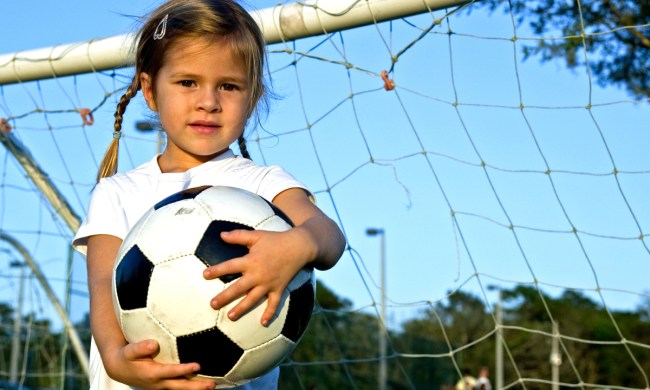 preschool girl having fun playing soccer