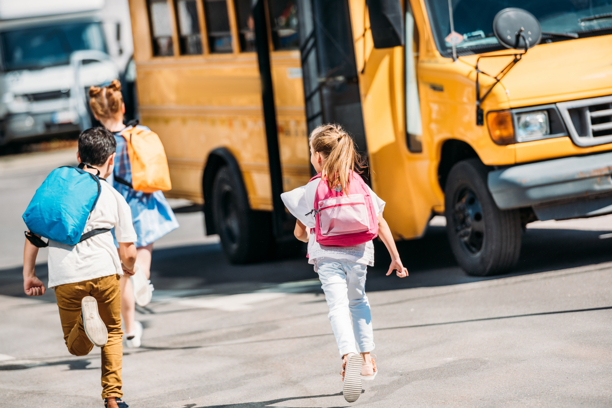 Kids running to a school bus.