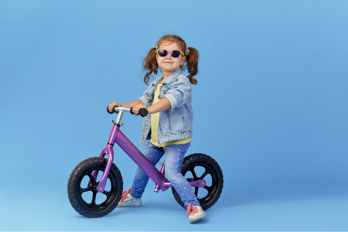 A little girl on a balance bike.