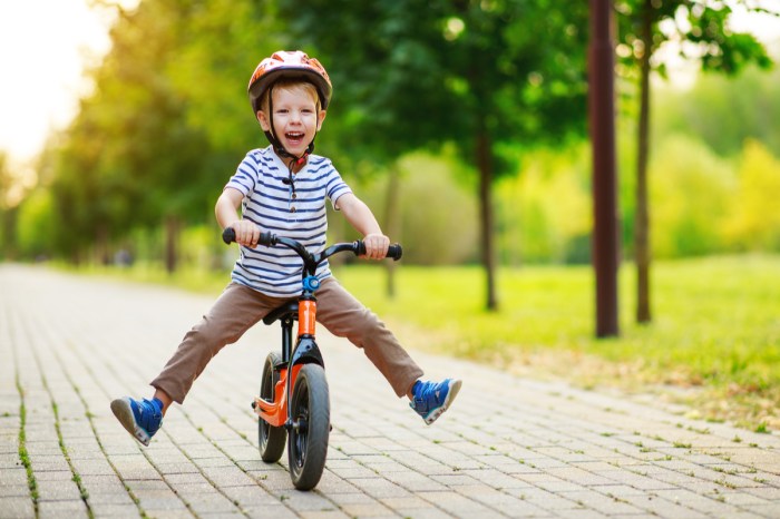 A toddler boy riding a bike.