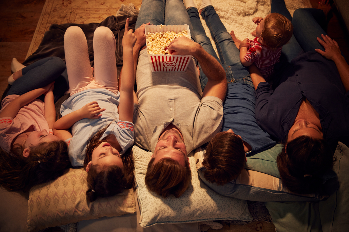 A family laying down watching a movie.