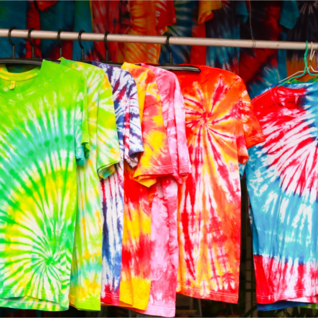 Colorful tie-dye shirts hanging on a line.