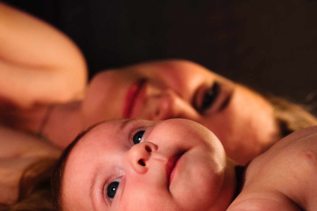 a close-up of a woman and baby lying down together