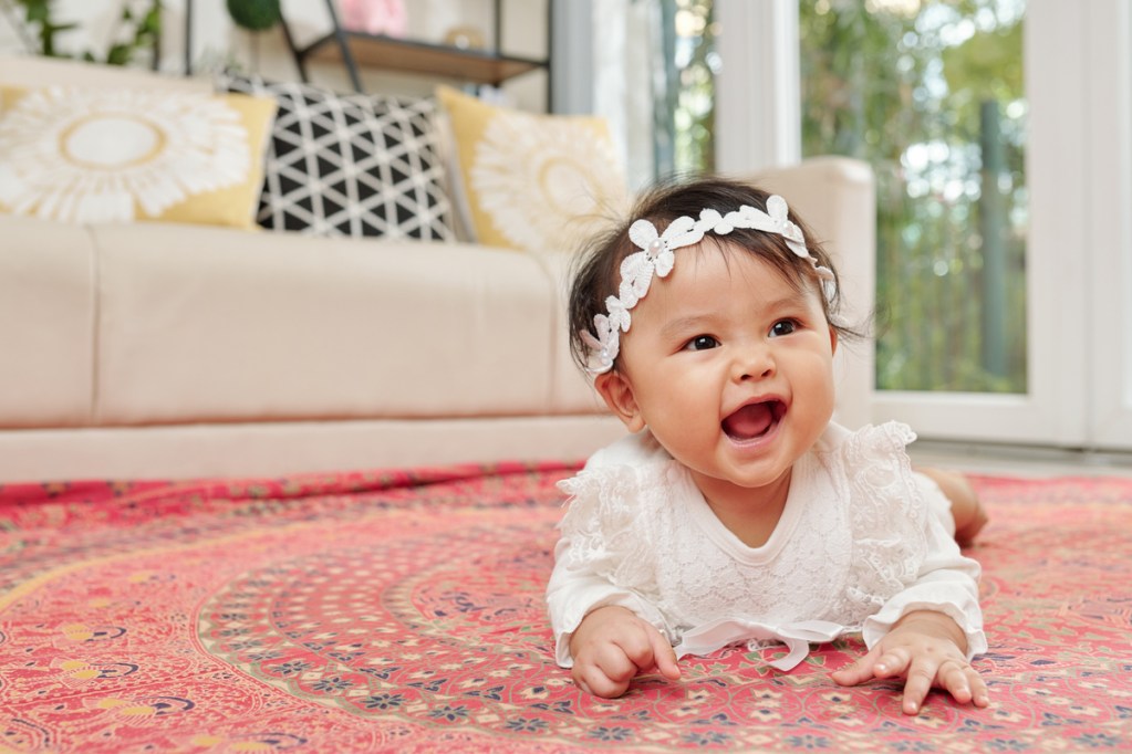 A baby on their stomach holding themselves up.