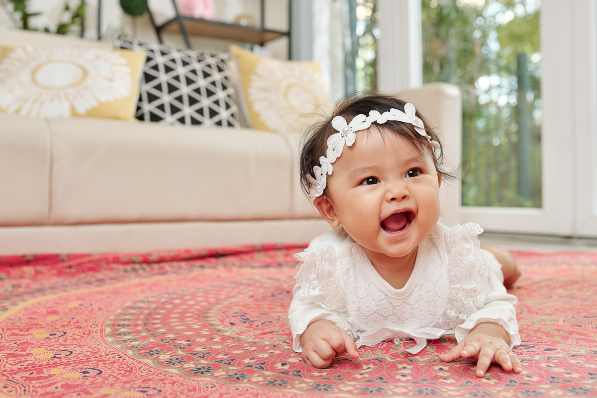 A baby on their stomach holding themselves up.