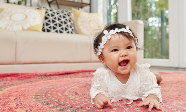 A baby on their stomach holding themselves up.