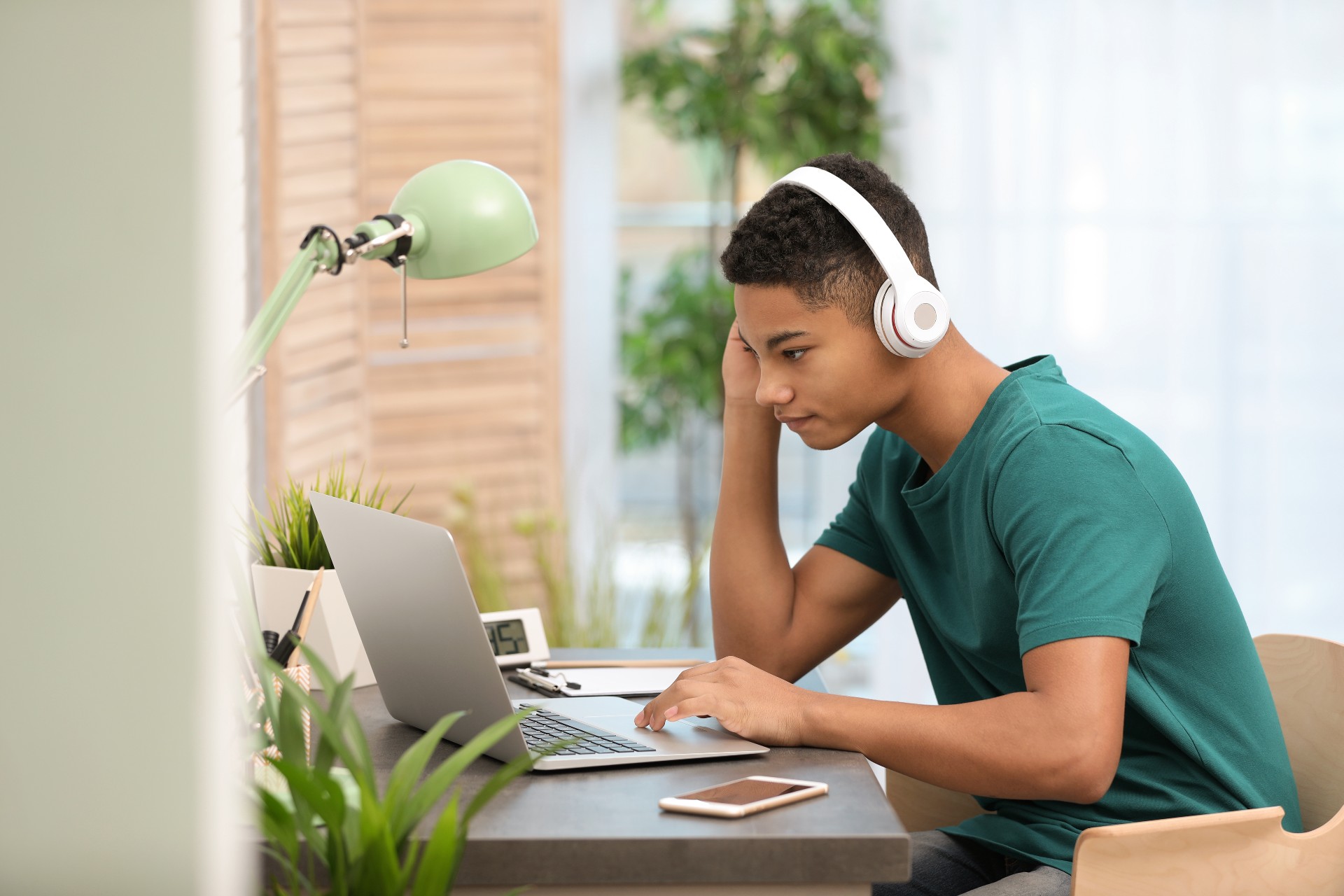 Teen doing homework with headphones on