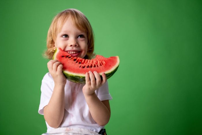 child eating a big slice of watermelon