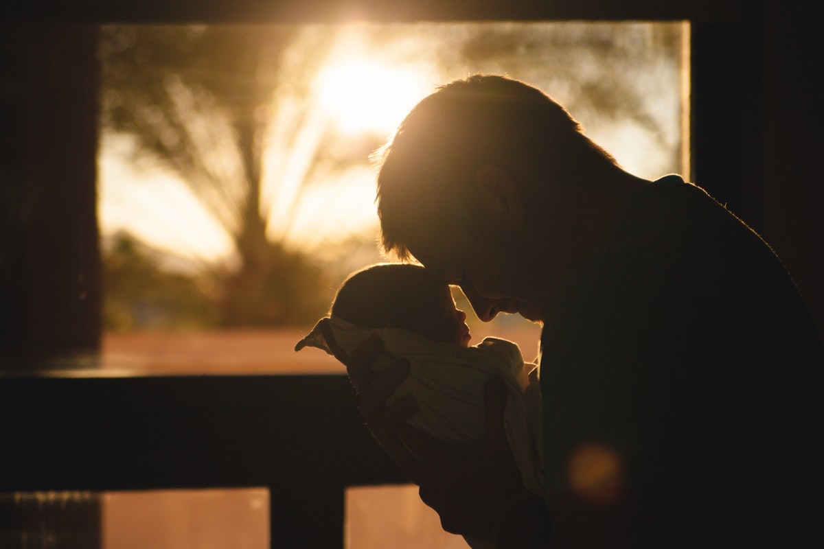 silhouette of dad holding baby