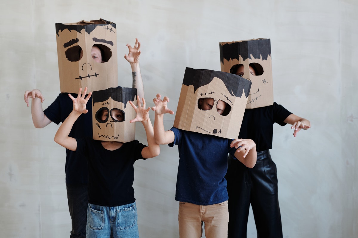 family wearing Halloween masks made from boxes