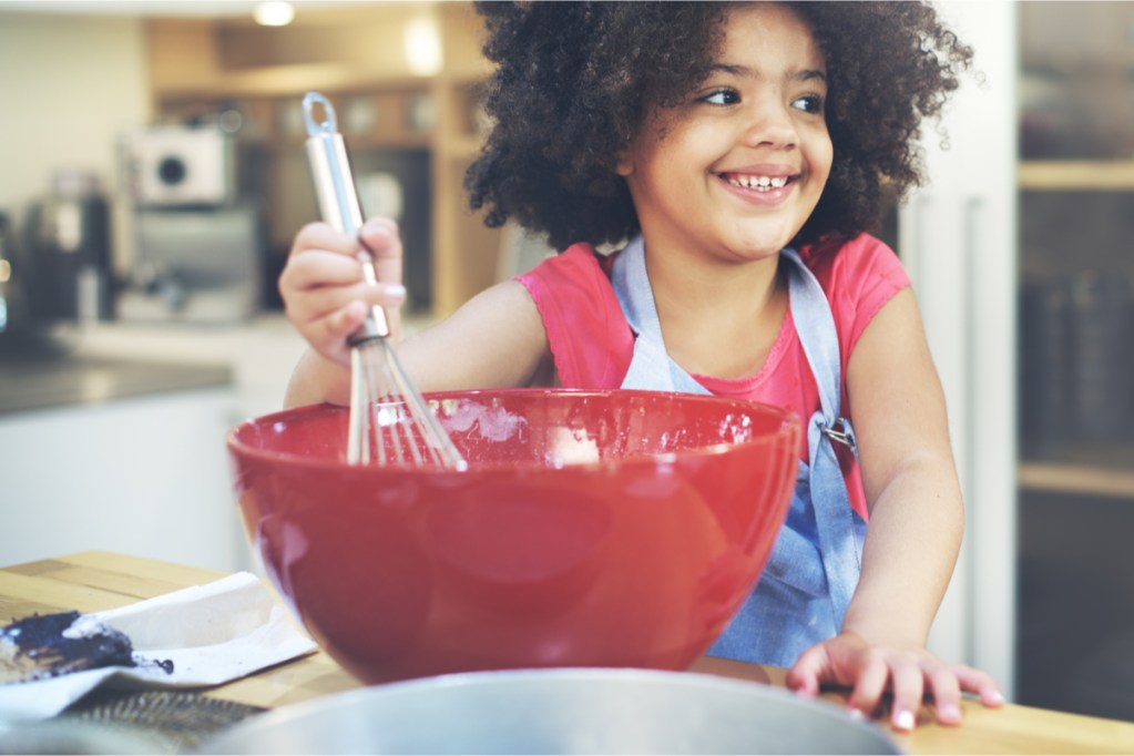 young girl having fun cooking in the kitchen