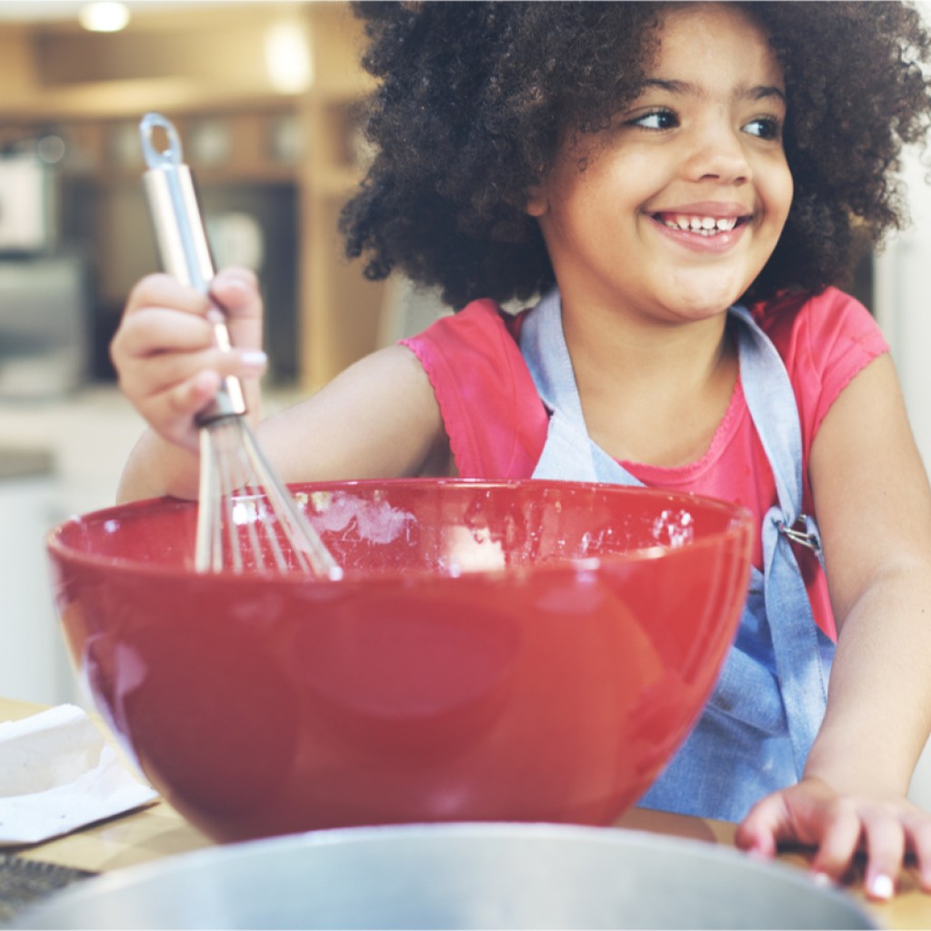 Young girl having fun cooking in the kitchen