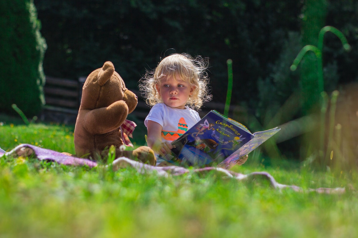 little girl with book and toys